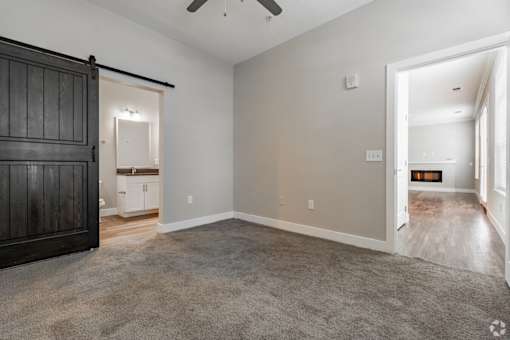 A room with a carpeted floor and a ceiling fan.