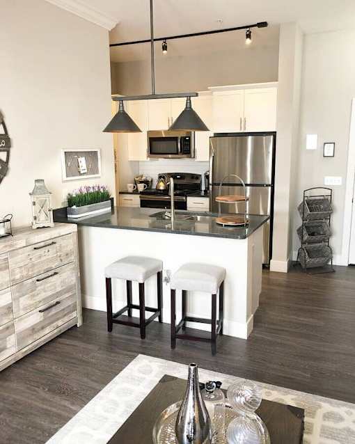 A modern kitchen with a bar stool in front of the island.