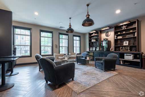 A living room with a black couch and a black chair.