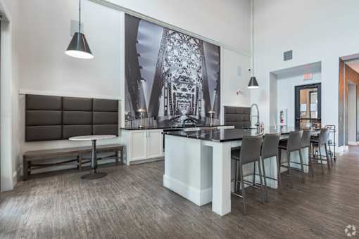 A modern kitchen with a long island and chairs.