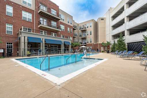 A large swimming pool in front of apartment buildings.
