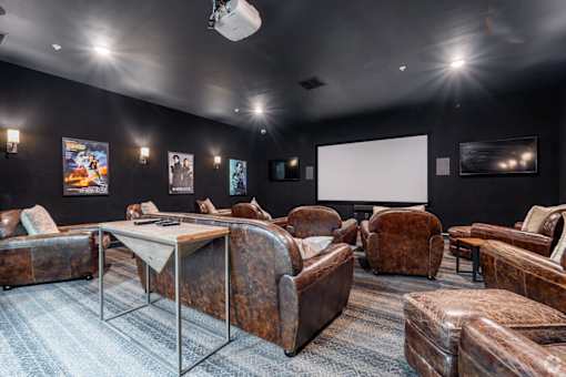 A room with a table and chairs and a screen.