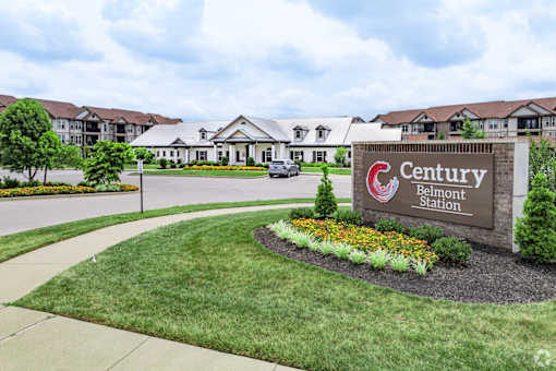 A sign for Century Belmont Station in front of a building.