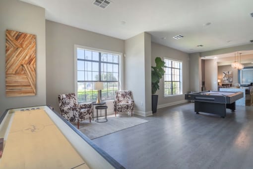 a living room with a pool table and two chairs at Century South Shore, League City, TX, 77573
