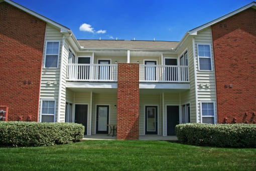 the outside of an apartment building with grass and bushes at Chester Village Green Apartments, Chester, 23831