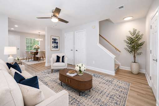 A living room with a white couch, a coffee table, and a ceiling fan.