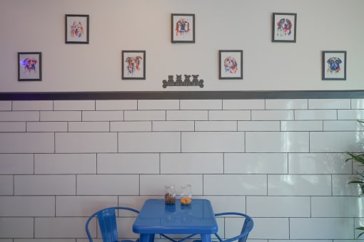a blue table and chairs in front of a white tiled wall
