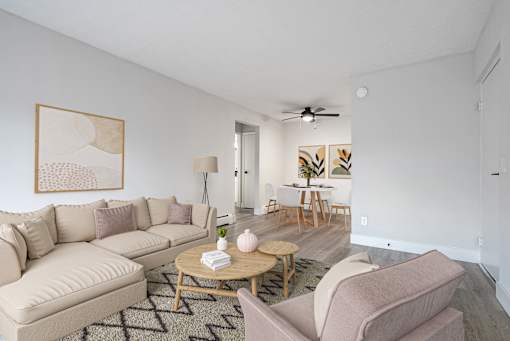 A living room with a beige couch, a coffee table, and a painting on the wall.