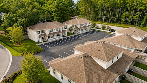 A large white building with a parking lot in front.
