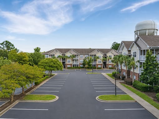 A parking lot in front of a residential building.