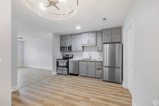 A kitchen with a refrigerator, oven, and microwave.