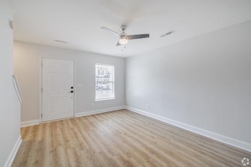 A room with a ceiling fan and a door.