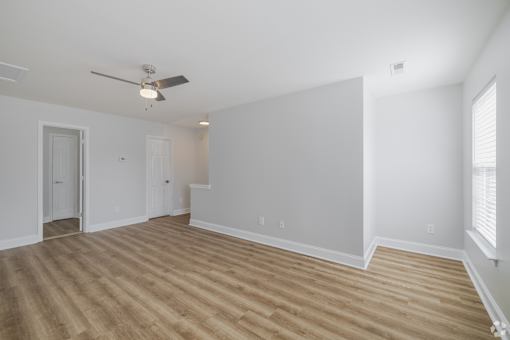A room with a ceiling fan and light fixture.