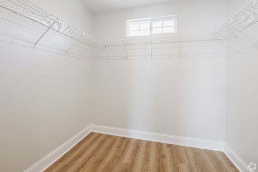 Empty room with a window and wooden floor.