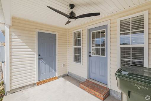 A blue door is on the left side of a white house.