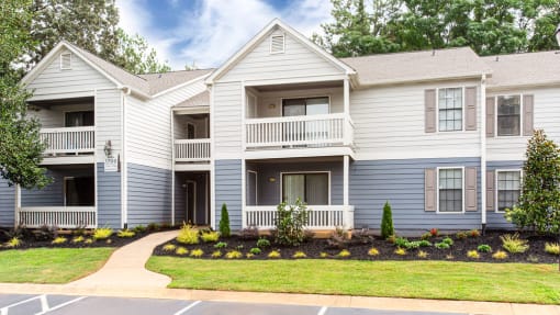 a large white house with a sidewalk in front of it at Magnolia Place at Stockbridge Apartments, Stockbridge, GA, 30281