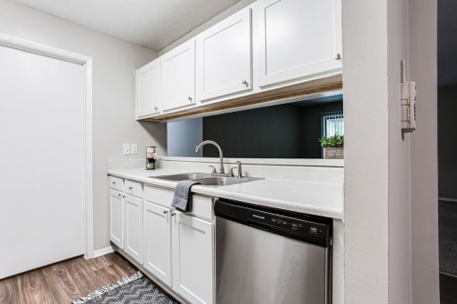 a kitchen with a dishwasher and white cabinets at Magnolia Place at Stockbridge Apartments, Stockbridge, GA
