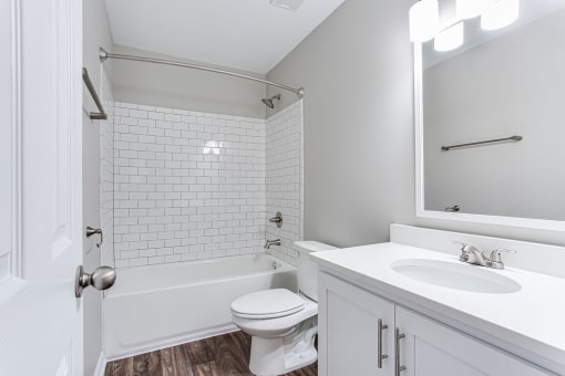 a white bathroom with a sink and a toilet at Magnolia Place at Stockbridge Apartments, Stockbridge, GA