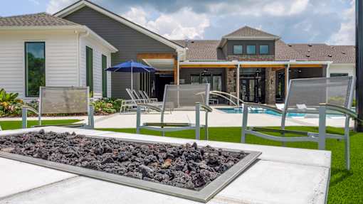 A modern house with a pool and a fire pit in the backyard.