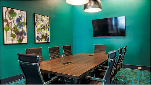 A conference room with a long table and chairs.