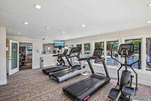 A gym with treadmills and elliptical machines.