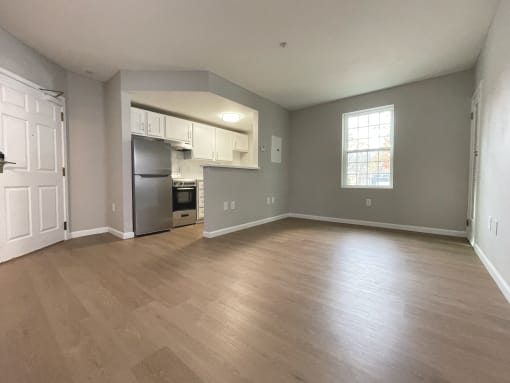 the living room and kitchen of an empty apartment