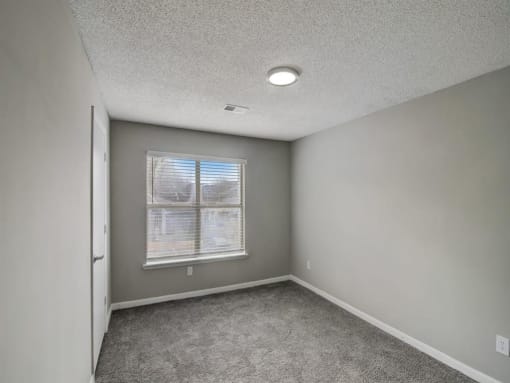 an empty room with a window and carpet at The Sapphire, Decatur, 30035