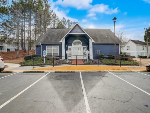 an empty parking lot in front of a blue house at The Sapphire, Decatur, GA