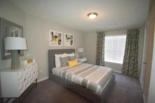 a bedroom with a bed and a dresser and a window  at The Sapphire, Georgia, 30035