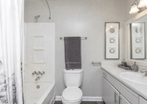 a white bathroom with a toilet and a sink at The Sapphire, Decatur, GA, 30035