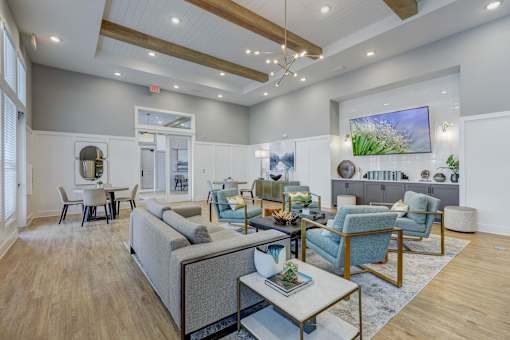 a living room with couches and chairs and a table at Century Mundy Mill Apartments, Oakwood, GA 30566