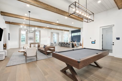 an open living room with a pool table in the middle