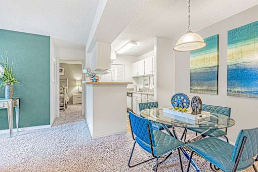 A dining room with a glass table and blue chairs. at Grove at St. Andrews, Columbia