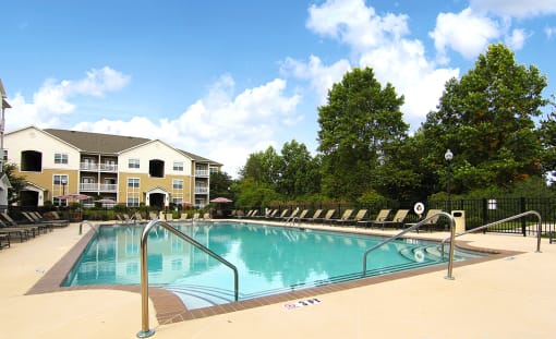Sparkling pool with sundeck and lounge chairs at the Haven at Reed Creek Apartments Martinez, GA