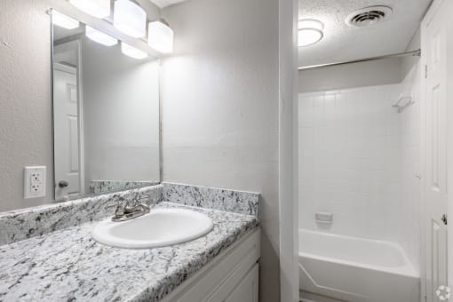 a bathroom with a sink and a bathtub at Summit Augusta, Augusta, GA