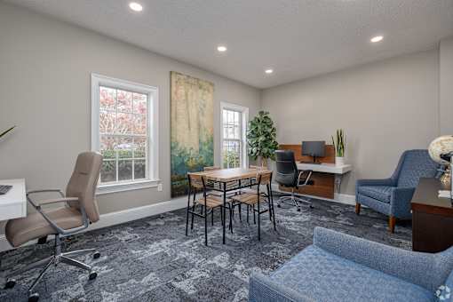 A room with a blue chair and a desk with a computer.