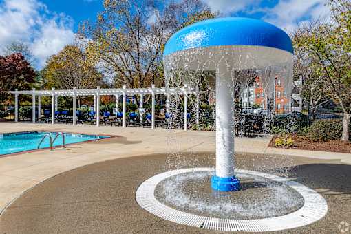 A blue and white water fountain in the middle of a pool area.