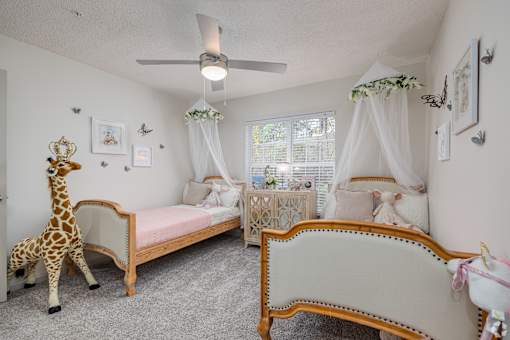 A room with two beds and a giraffe toy.