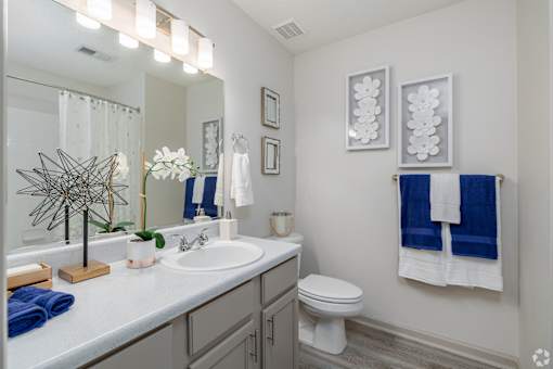 A bathroom with a white sink and a toilet.