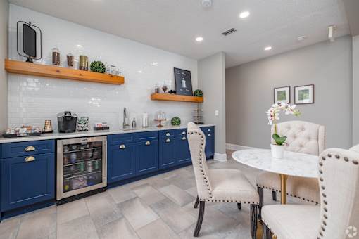 A kitchen with blue cabinets and a white table.