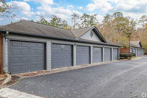 A two-car garage with a brick wall and a gabled roof.