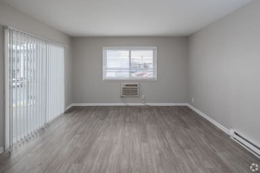 an empty room with a radiator and blinds
