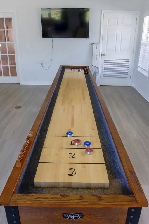 a shuffleboard table in a living room with a tv at Retreat at Savannah, Savannah, 31404