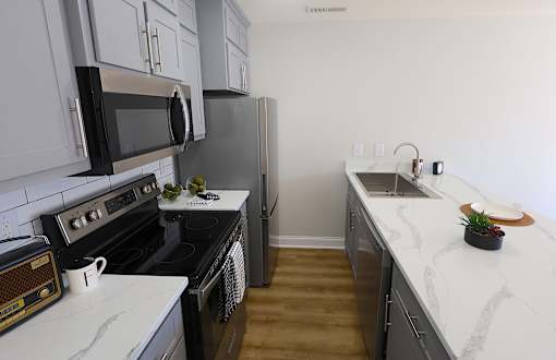A kitchen with black appliances and white cabinets.