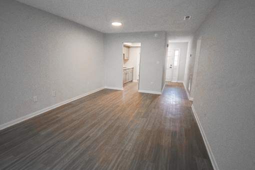 A room with wooden flooring and white walls.