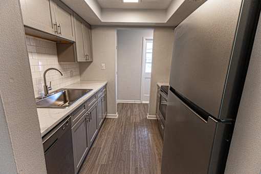 A kitchen with a refrigerator on the right.