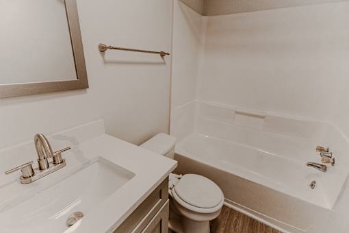 A white bathroom with a sink, toilet and bathtub.