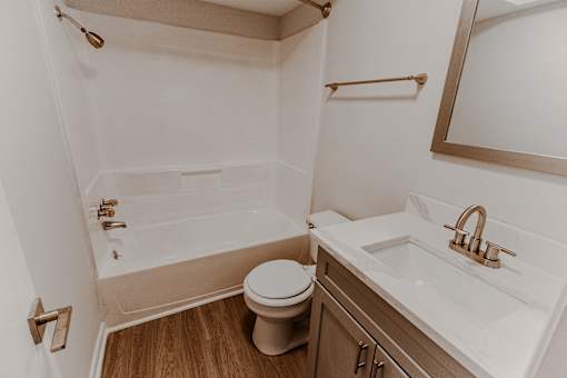 A white bathroom with a toilet, sink, and bathtub.