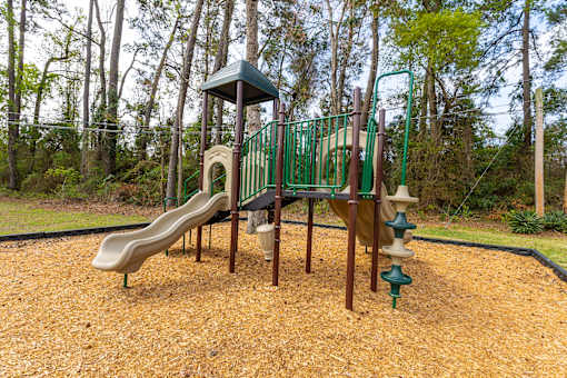 A playground with a green slide and a brown slide.