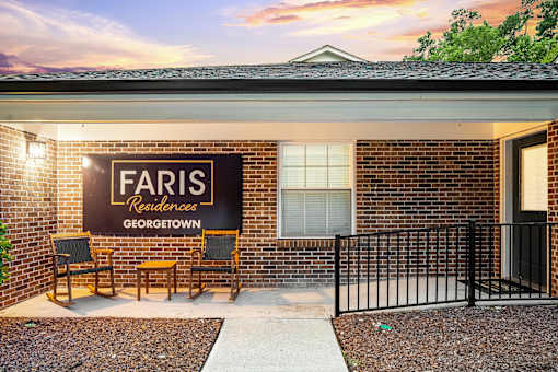 A sign that says "Faris Residences Georgetown" is on a brick wall.